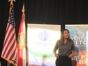 a woman speaking on a stage at venturepitch